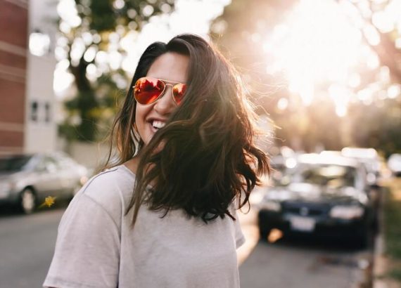 A girl smiling wearing sunglasses